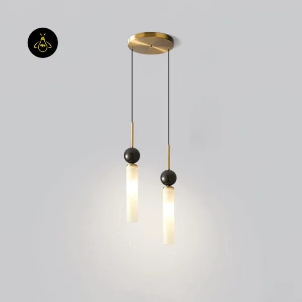 Double marble pendant light lit, white marble cylinders glowing warm under black marble spheres