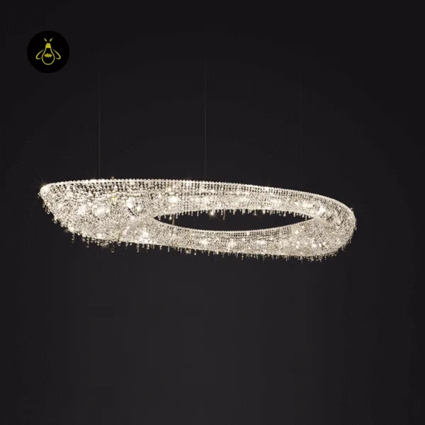 Linear crystal chandelier glowing warm over a dining room with sparkling clear crystal light