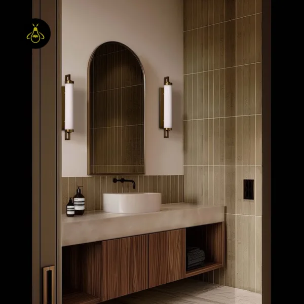 Pair of fluted glass vanity lights in satin brass beside an arched bathroom mirror over a walnut vanity