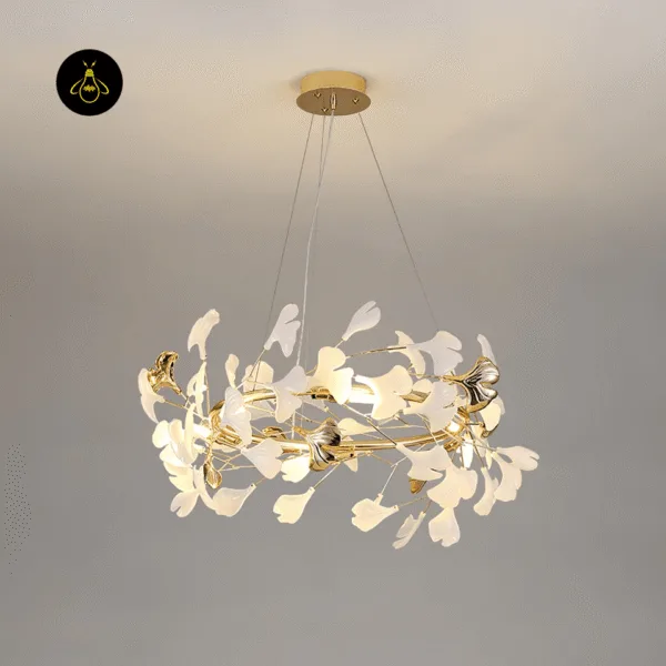 Ginkgo leaf chandelier lit with a warm G9 glow among white ceramic leaves