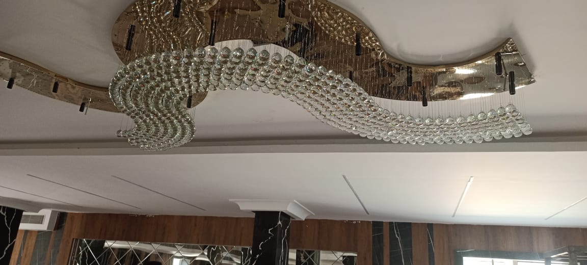 Wave-shaped crystal chandelier glowing above the Visakhapatnam banquet hall