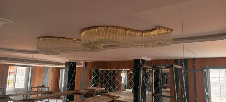 Wide banquet ceiling view with custom crystal wave chandelier in Visakhapatnam