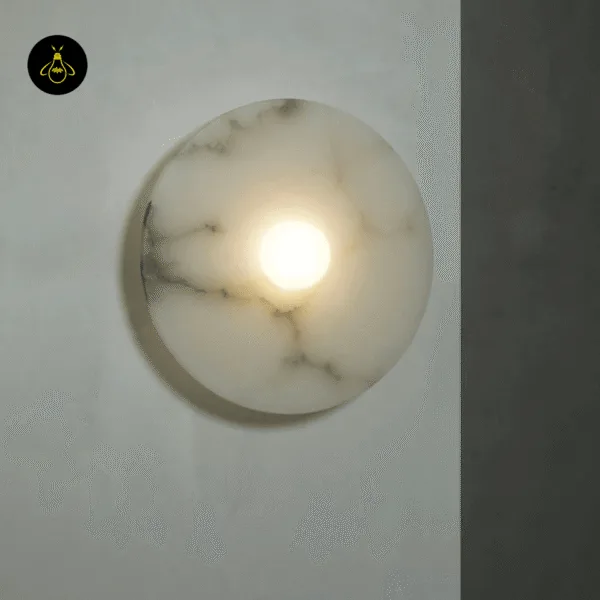 Disc wall light lit up, white alabaster with grey veins glowing warm around the centre lens