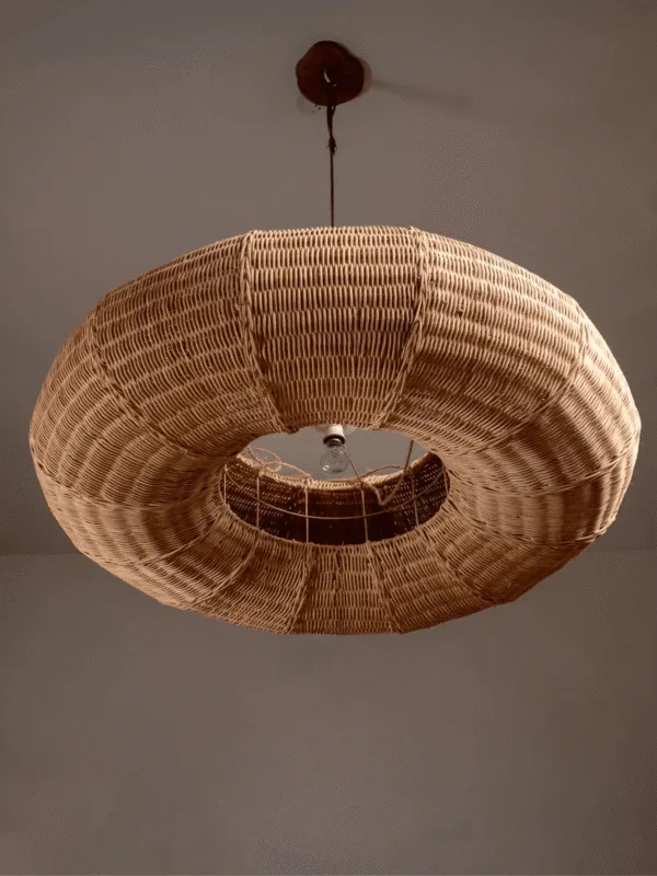 Cane frame pendant light seen from below, showing the open centre of the woven rattan ring and the round ceiling canopy