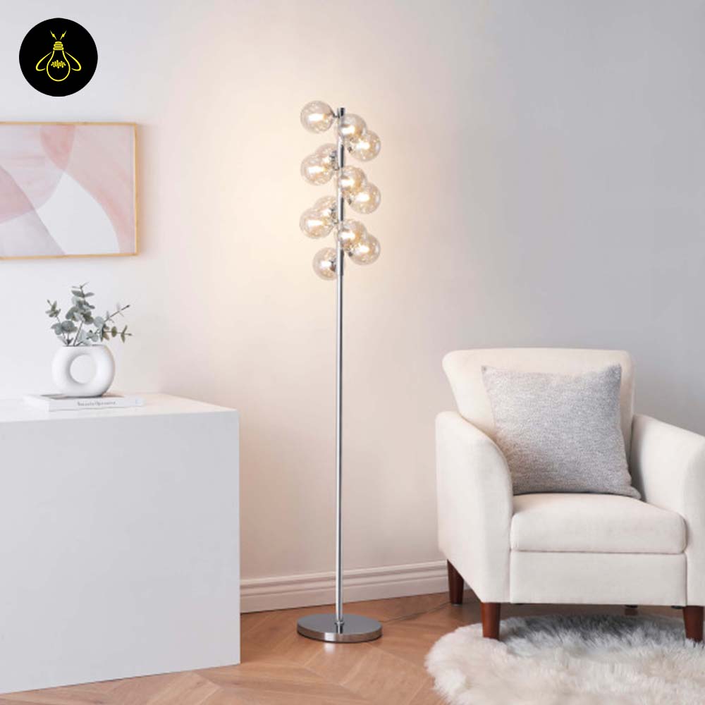 Amber glass floor lamp with chrome frame beside an accent chair