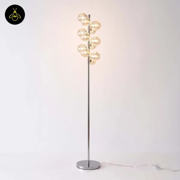 Amber glass floor lamp with warm glow on a plain background
