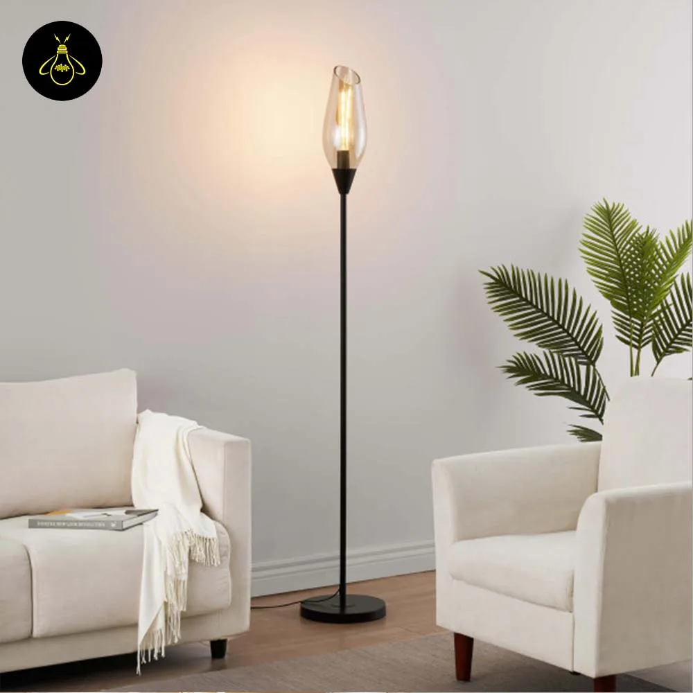 Black amber glass floor lamp casting warm ambient light in a modern interior