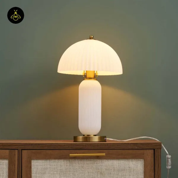 Lit fluted glass mushroom table lamp glowing warm white on a sideboard