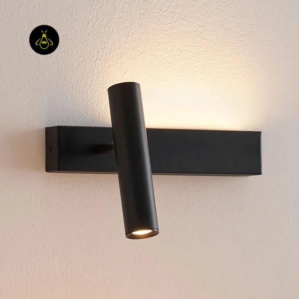 Close view of the matte black wall reading lamp with its reading head tilted and the up-light on