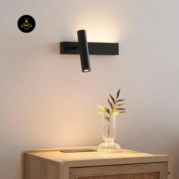 Matte black wall reading lamp above a wooden bedside table with rattan front and a glass vase