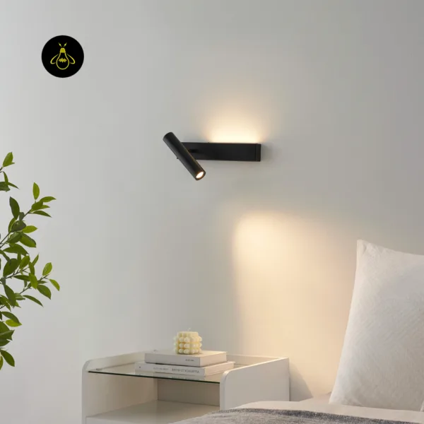 Black wall reading lamp lighting a white bedside table beside a bed