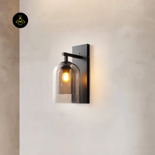 Fancy lights for wall on a plaster wall: smoked borosilicate glass double-cloche sconce on a matte black stainless steel backplate, lit warm