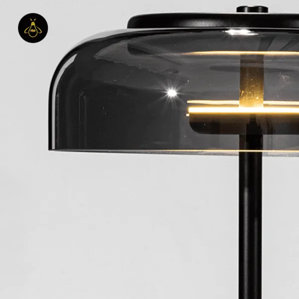 Detail of the built-in warm LED inside the smoked borosilicate glass dome of the black table lamp