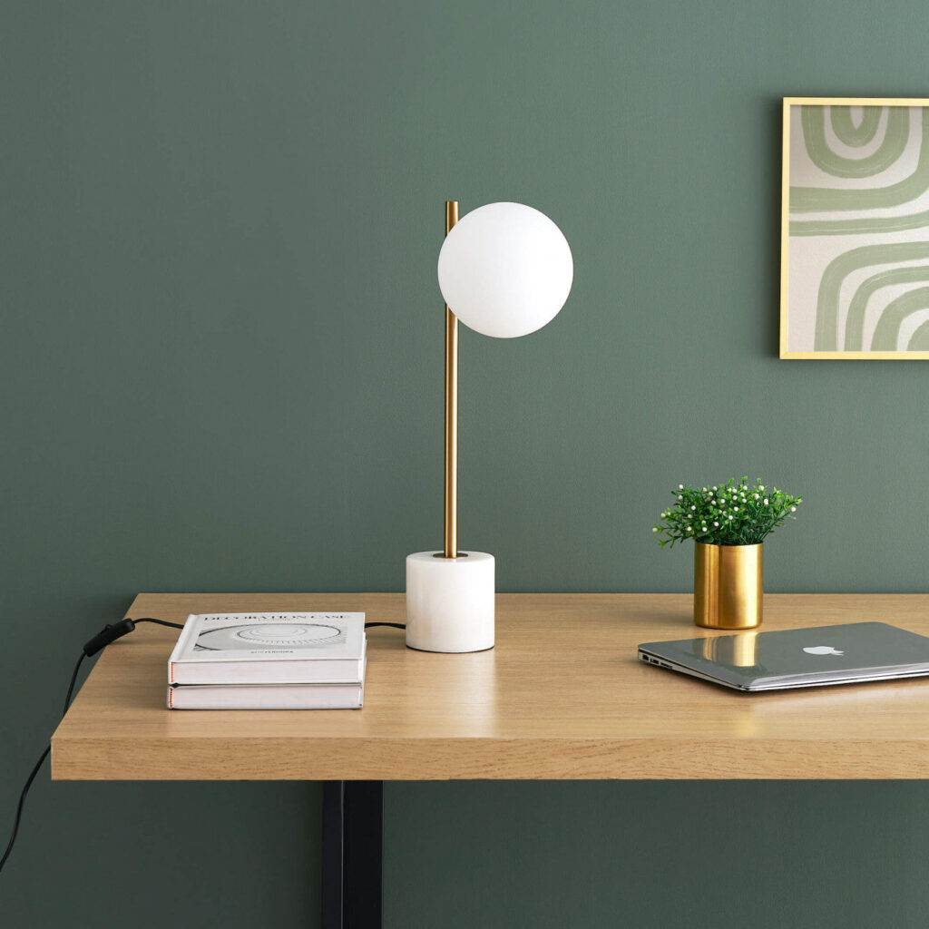 Close-up of the marble table lamp with white glass globe and brass arm