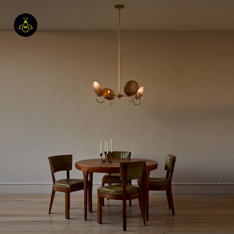 Wood and brass chandelier hanging above a dining table in a warm interior