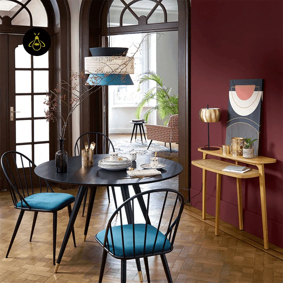 Cane & Fabric Layered Drum Pendant Light – 45 cm 5 Teal and black cane pendant hanging over a round dark dining table with teal-cushioned chairs and a maroon wall