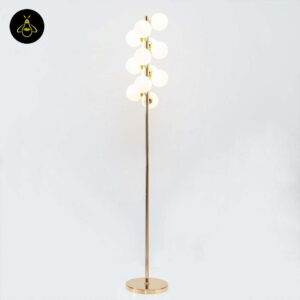 Gold floor lamp with 12 white glass spheres creating soft ambient light in a modern interior