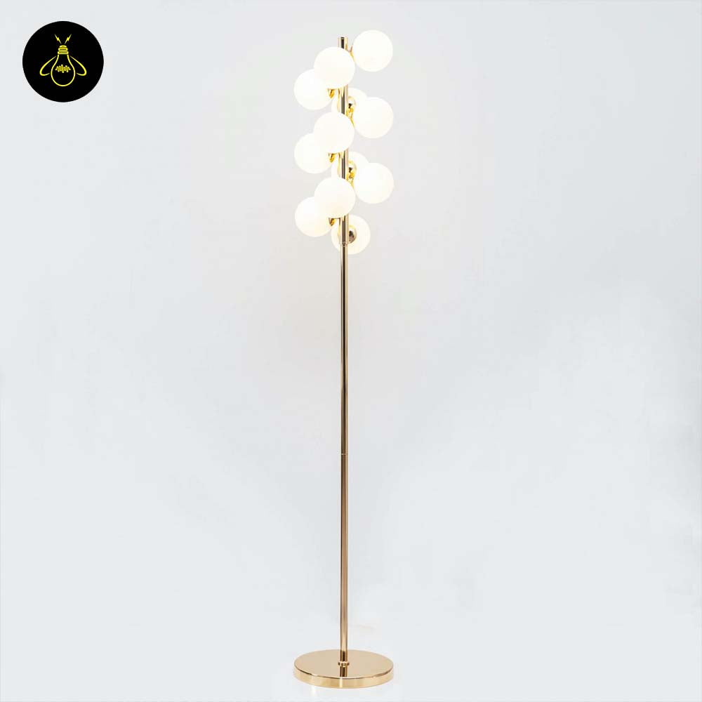 Gold floor lamp with 12 white glass spheres creating soft ambient light in a modern interior
