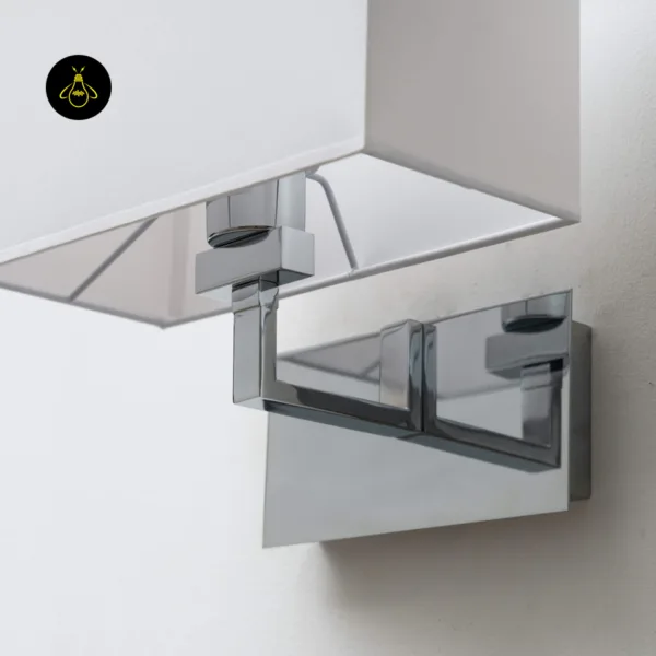 Polished chrome 304 stainless steel arm and backplate holding the wall lamp with shade, close-up