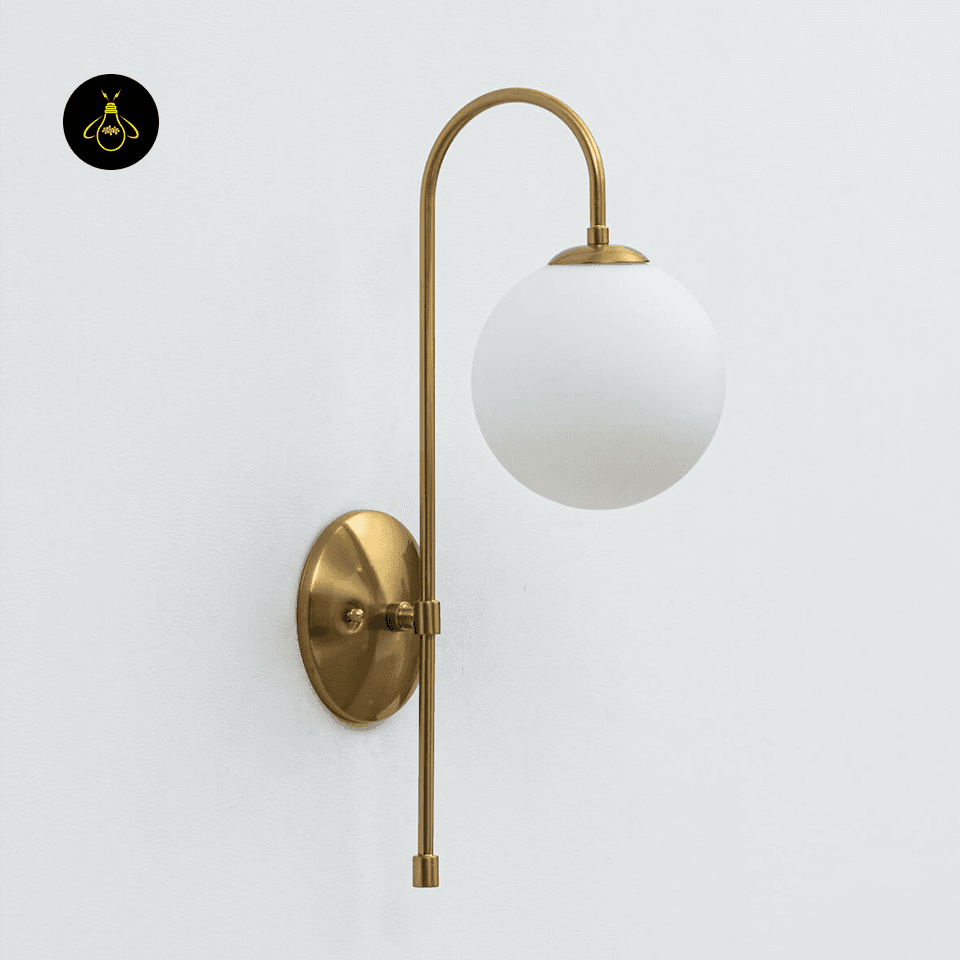 Gold Wall Light for Living Room – Oriol 48 cm Globe Sconce 2 Gold wall light glowing in a hallway with a soft frosted-glass globe and warm ambient light