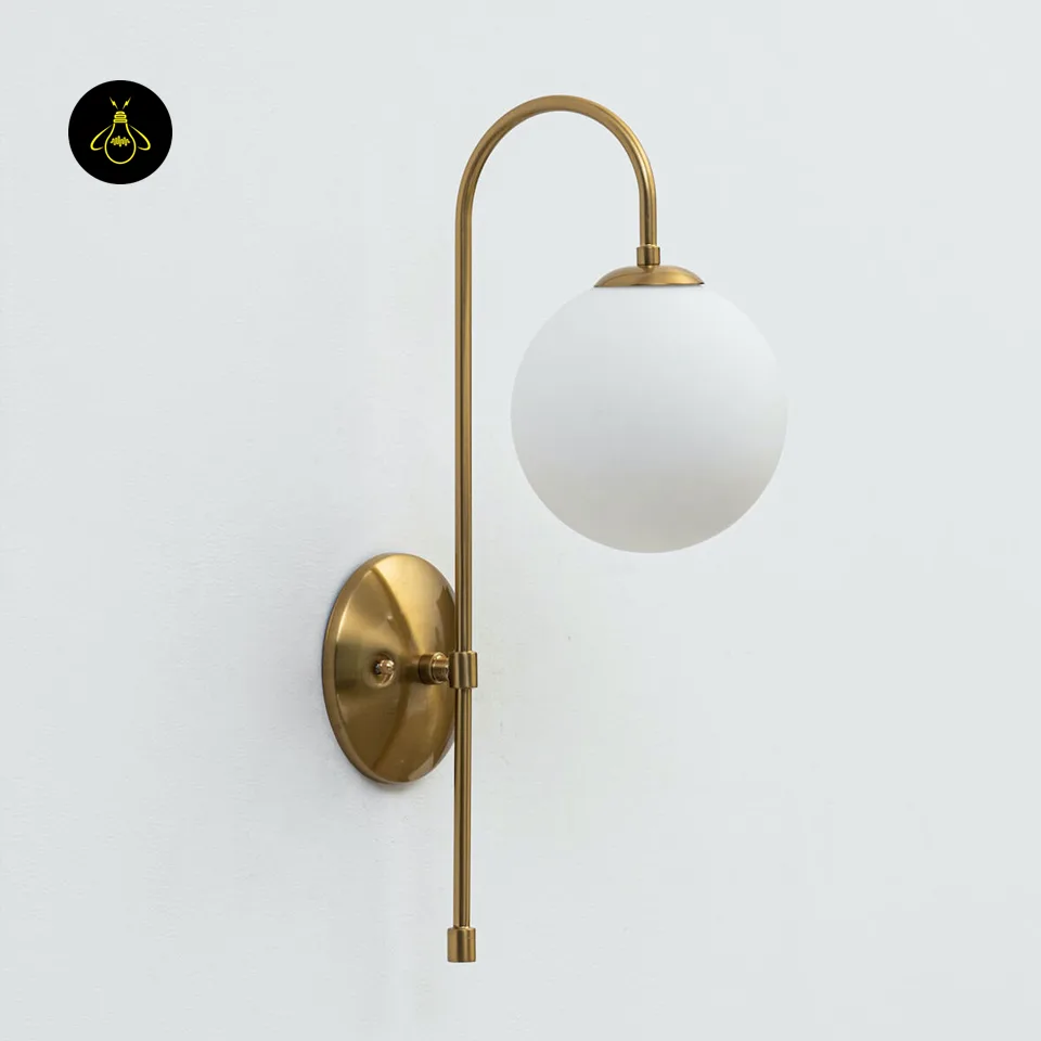 Oriol Frosted Glass Globe Wall Sconce – 48 cm Antique Gold Arch | Jagmag Lights 2 Gold wall light glowing in a hallway with a soft frosted-glass globe and warm ambient light
