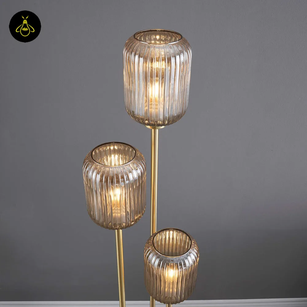 Triple Amber Glass Floor Lamp – 3-Light Gold Ribbed Glass Statement 3 Triple amber glass floor lamp lit with a warm amber glow in a living room