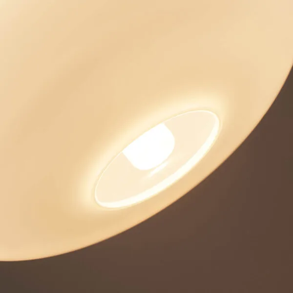Looking up into an opaline glass pendant light: the bulb glows through the open base of the opal shade