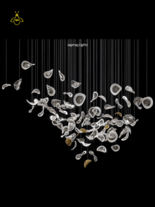 Glass jhumar chandelier suspended over a dining table with warm LED-lit glass leaves