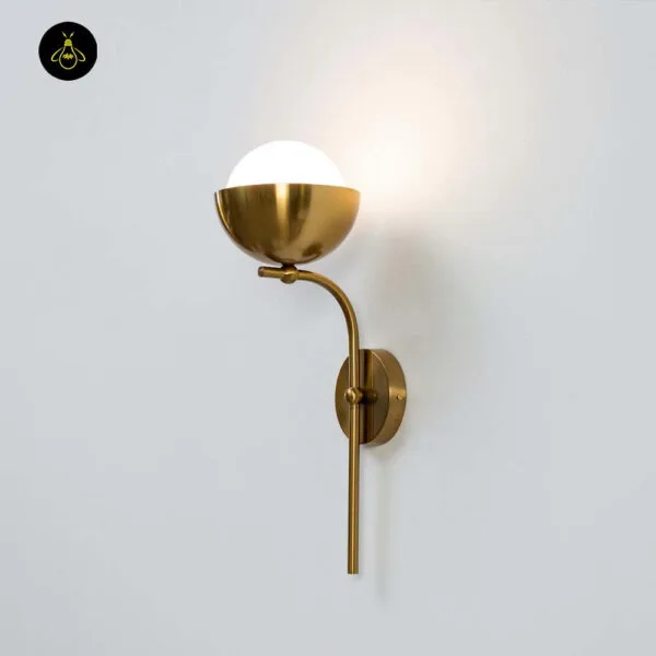 Opal white light glowing warm on a white wall, brass-finish cup holding the opal borosilicate glass globe