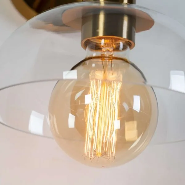 Close-up of a globe bulb inside the clear borosilicate glass shade of the dome wall light (bulb not included)