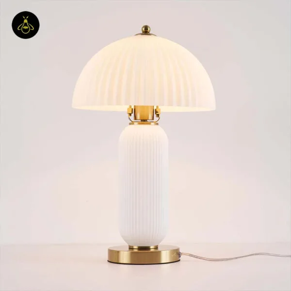 Fluted glass mushroom table lamp lit with a warm E27 bulb