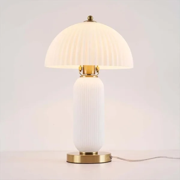 Fluted glass mushroom table lamp lit with a warm E27 bulb