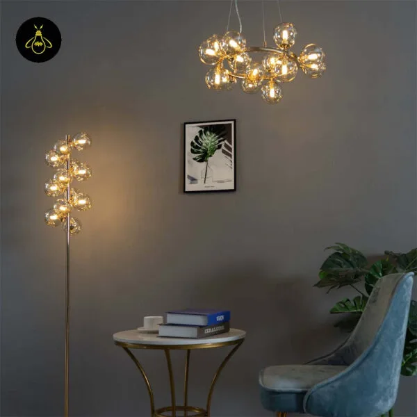 Gold floor lamp with amber borosilicate glass spheres lit in a modern room