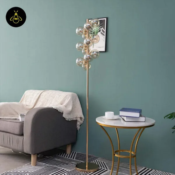 Gold floor lamp with amber borosilicate glass spheres in a hotel-style interior