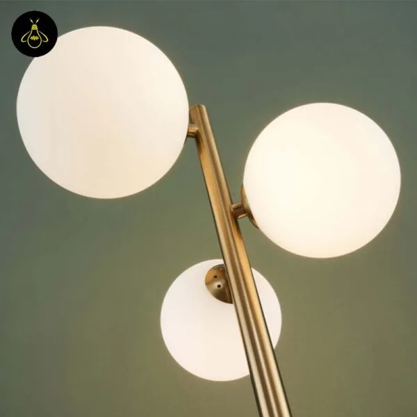 White opal globes glowing warm on the gold-lustre borosilicate glass globe floor lamp