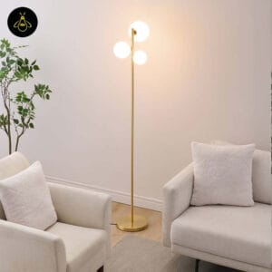 Front view of the gold glass globe floor lamp lighting a living room seating area