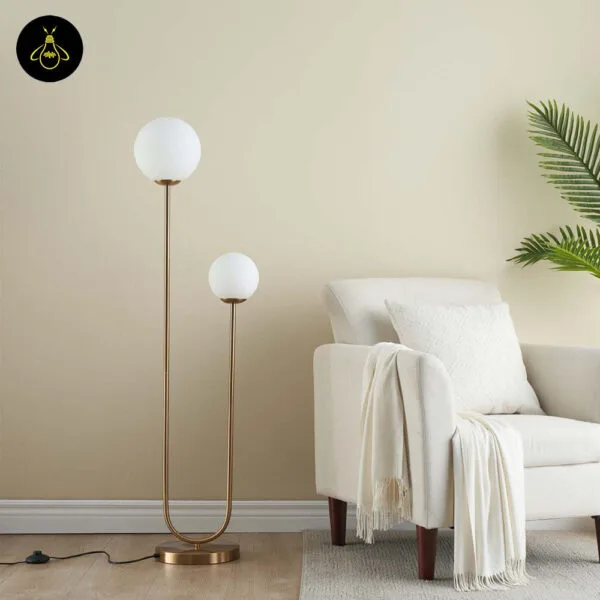 Brass dual globe floor lamp with softly glowing opal globes
