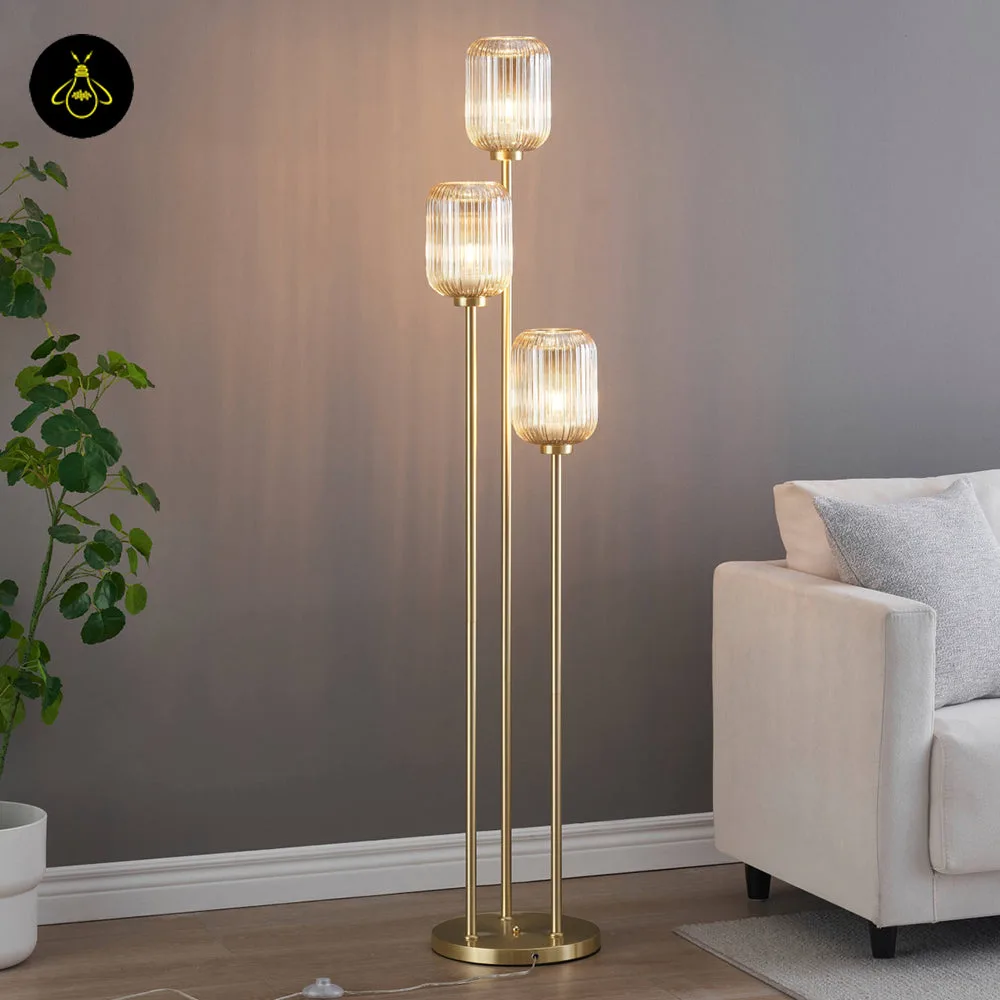 Triple amber glass floor lamp with gold frame in a modern living room