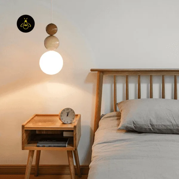 Glass ball pendant light glowing beside a wooden bed over an oak nightstand
