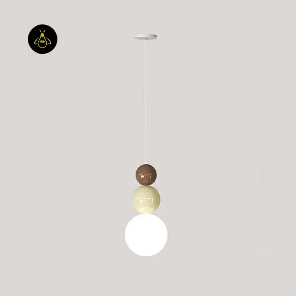 Totem pendant light with three stacked glass balls in brown, beige and opal white against a grey wall