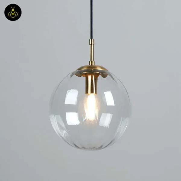 Front view of the ribbed glass ball pendant light hanging against a grey wall, bulb glowing inside