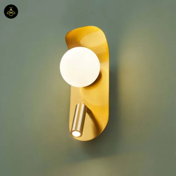 Bedroom reading light with both lights on: opal borosilicate glass globe and LED reading spot on a curved brushed gold leaf