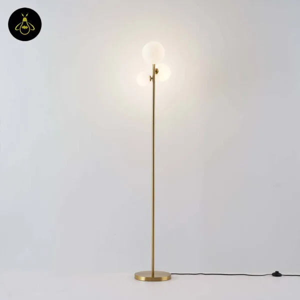 Full-length gold-lustre borosilicate glass globe floor lamp with three white opal spheres on a white background