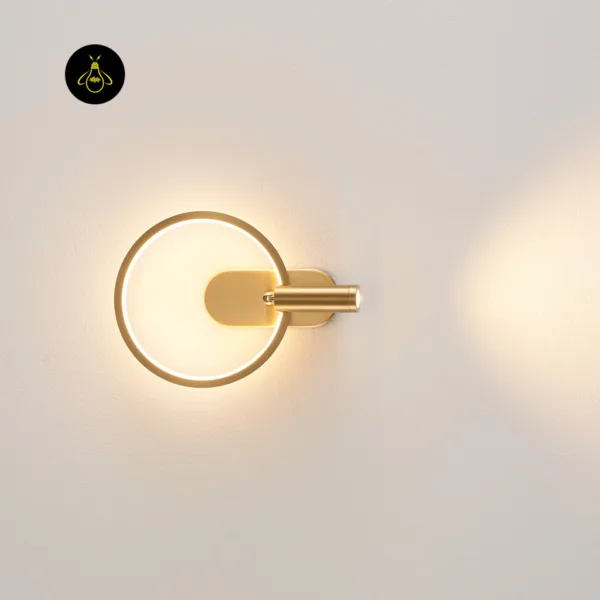 Gold circle wall light on a pale wall with the reading spot turned to the side