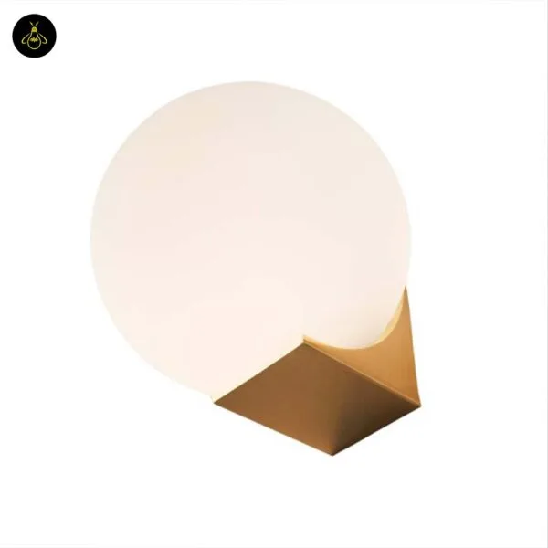 Globe wall light switched off, opal borosilicate glass ball on a brushed-gold base on a white background
