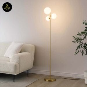 Gold glass globe floor lamp lighting a corner beside a cream sofa in a living room