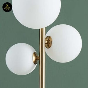 Close-up of three white opal globes, 15, 12 and 10 cm, on the gold glass globe floor lamp
