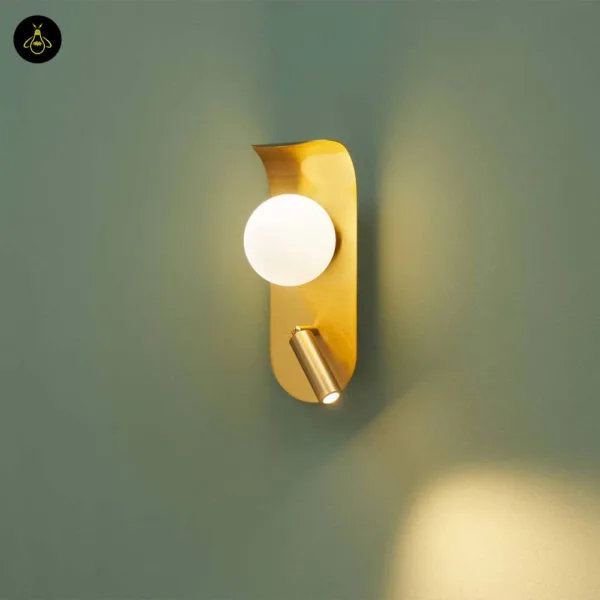Bedroom reading light throwing a pool of warm light down a green wall from its LED reading spot, with the opal borosilicate glass globe lit above