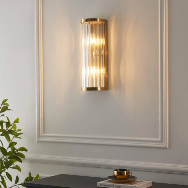 Lit ribbed glass wall light on a panelled wall above a dark console with a cup and saucer