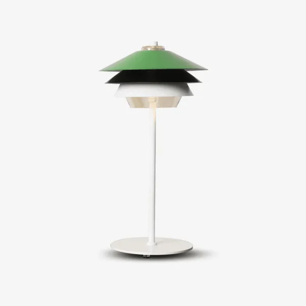 Green table lamp with green, black and white steel tiers over a clear glass diffuser, on a white stem and base